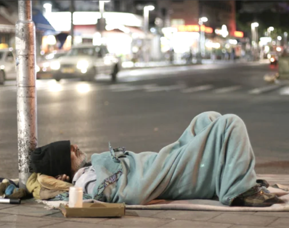 A homeless man sleeping at night at the street corner San Diego, CA